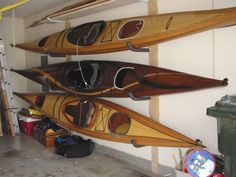 several canoes are lined up on the wall next to each other in a garage