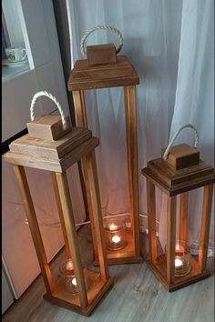 three wooden lanterns with rope on them