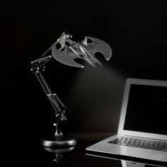 a laptop computer sitting on top of a desk next to a light and a lamp