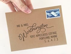 a hand holding a brown envelope with a stamp on it that says mr and mrs worthington