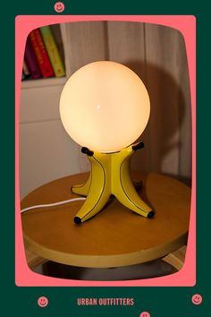 a yellow table lamp sitting on top of a wooden table