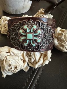 Country leather bracelet cuff, western jewelry  Embossed distressed genuine brown leather 1 1/2" strap has been adorned with a copper flower with turquoise color inlay concho and sets on a detailed antiqued copper filigree. It is attached to the leather with two antiqued copper rivets. One antiqued copper snap has been placed to fit up to a 7" wrist. ✨I CAN ADD ANOTHER SNAP IF YOU WOULD LIKE A SMALLER OR LARGER SIZE BUT YOU NEED TO MESSAGE ME BEFORE PURCHASING     The last photo features other items available for purchase in my shop and not included in this listing I can also design this using vegan leather. If interested, just convo me and I'll send you a photo other cuffs available https://www.etsy.com/shop/AsYouWishgallery?ref=seller-platform-mcnav§ion_id=18358191 ✨Please feel free to v Adjustable Brown Western Cuff Bracelet, Western Style Turquoise Bracelet, Hand Tooled, Western Brown Hand-tooled Jewelry, Hand Tooled Brown Rustic Leather Bracelet, Hand Tooled Brown Leather Rustic Bracelet, Vintage Brown Hand Tooled Cuff Bracelet, Brown Hand Tooled Rustic Leather Bracelet, Vintage Brown Hand-tooled Cuff Bracelet, Rustic Brown Bracelet With Concho