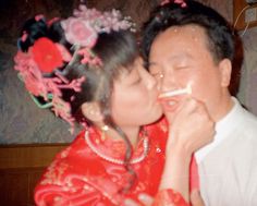 a man and woman kissing each other while wearing traditional chinese garb with flowers on their head