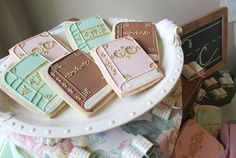 decorated cookies are sitting on a platter next to some cards and other small items