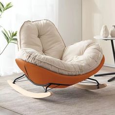 an orange and white rocking chair sitting on top of a rug