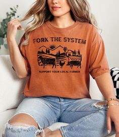 Get ready to dig in with our phunny Retro 'Fork the System, Support Your Local Farmer shirt! Skip the grocery store and go straight to the source. What the fork are you waiting for? Snag one for yourself and another for your bestie to wear while exploring the local farmers market.  🌱SHIRT Comfort Colors 1717 garmet-dyed t-shirt Unisex adult sizing 100% ring-spun cotton Made using 100% US cotton  Double-needle stitching Medium fabric Relaxed fit Sewn-in twill label 🌱PRINT Direct-to-garment prin Support Your Local Farmer, What The Fork, Gifts For Gardeners, Farm Tshirt, Local Gifts, Local Farmers Market, Vinyl Shirts