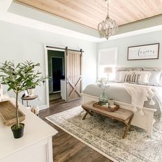 a bedroom with a large bed and wooden ceiling beams in the room, along with a rug on the floor