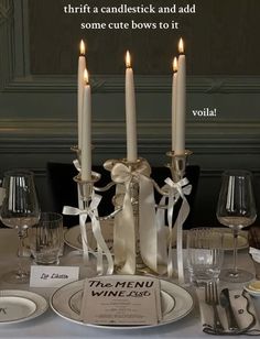 there is a table set with candles and place settings