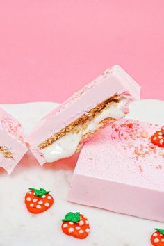 two pieces of cake sitting next to each other on a white surface with strawberries