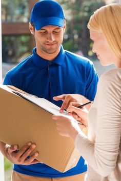 a man and woman in blue uniforms are looking at something on a clipboard