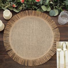 a place setting on a wooden table with flowers and candles