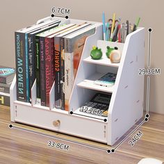 a book shelf with books and pencils in it on top of a wooden table