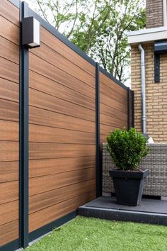 a wooden fence next to a potted plant