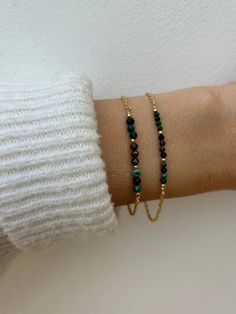 This dainty little bracelet combines three different gemstones which compliment each other and are often combined together. There include Malachite and Chrysocolla. Two stones  that naturally occur together, making them a perfect match for healing and manifestation.  And the third is tiger's eye which for centuries has been used as a protective amulet. D E T A I L S *Made with  a line up of high quality micro faceted gemstones  in between seamless gold filled beads.  *Choose between 2/2.5mm micro faceted gemstones or slightly larger ones measuring around 3mm. *The gemstones are malachite, tiger's eye and chrysocolla.  *Choose between a gold filled, rose gold-filled or sterling silver chain. *Bracelet comes with an explanatory crystal information card and care instructions and as with all o Malachite Gemstone Bracelets As Gift, Elegant Handmade Malachite Bracelets, Elegant Malachite Beaded Bracelets For Gift, Protective Amulet, Crystal Information, Multi Gemstone Bracelet, Bead Bar, Information Card, Tiger Eye Bracelet