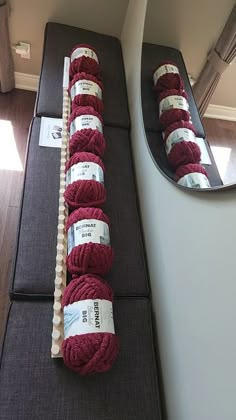 red balls of yarn sitting on top of a couch next to a mirror