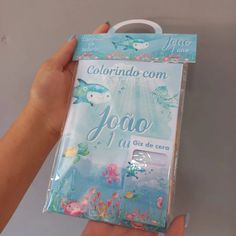 the package is being held up by a person's hand with an ocean theme on it