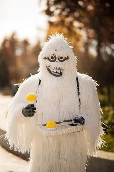 a man dressed as a monster holding two lemons and a tray with something in it