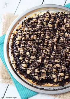 a chocolate cheesecake is sitting on top of a blue towel and white table cloth