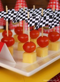 small appetizers are displayed on a plate with red and white striped paper cones