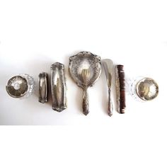 an assortment of antique silverware including spoons, forks and other items on a white surface