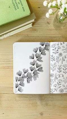 an open book on a wooden table with flowers