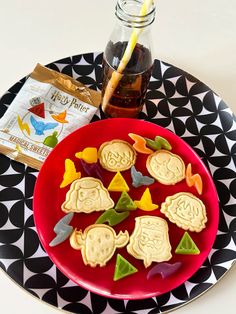 some cookies are on a red plate with a drink