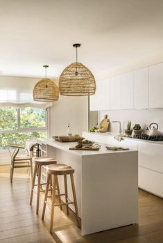 the kitchen is clean and ready to be used for cooking or eating, with two pendant lights hanging from the ceiling