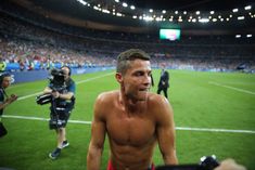 a man with no shirt on standing in front of a camera at a soccer game