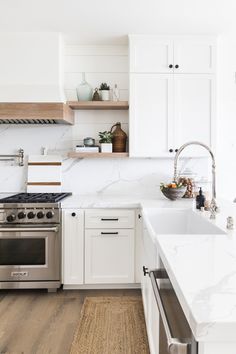 a kitchen with white cabinets and wood floors