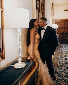 a man in a tuxedo kissing a woman in a gown