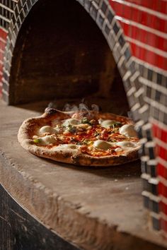 a pizza sitting on top of a stone oven