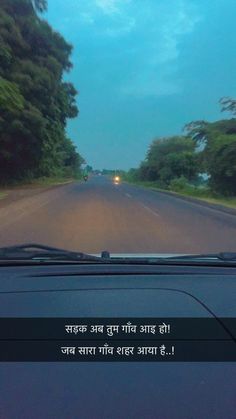 a car driving down a road with trees on both sides and the words written in english