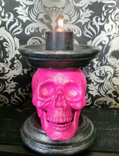 a candle holder with a pink skull on it