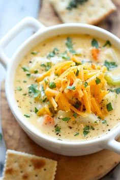 a bowl of cheese soup with crackers on the side