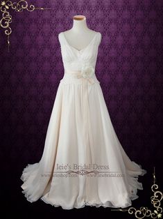 a wedding dress on display in front of a purple wall