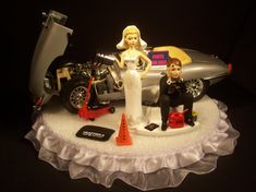 a wedding cake topper with a bride and groom next to a motorcycle