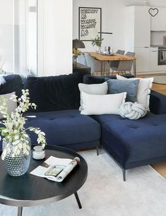 a living room filled with furniture next to a kitchen and dining room table on top of a hard wood floor