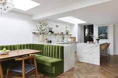 a green couch sitting in the middle of a kitchen