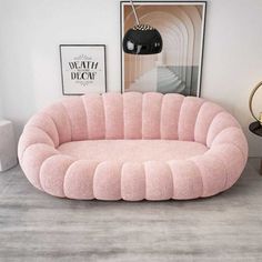 a pink couch sitting on top of a wooden floor