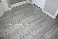 a bathroom with grey tile floors and white walls