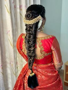 a woman with long hair in a red sari and gold jewelry on her head