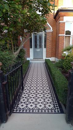 a black and white tiled walkway in front of a house