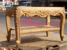 a wooden bench sitting on the side of a road