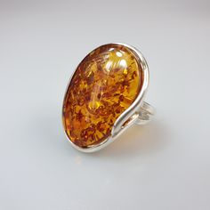 Amber ring. Sterling silver 925 genuine Amber ring. . Brown colour available. Adjustable size Stone size 2 x 3 cm. Weight 9,60 gr. Oval shape. This item was made of natural Baltic Amber. All the amber used in my jewelry is collected in my home country Lithuania. I sell only genuine, authentic, real, natural Baltic Amber. Item may have natural imperfections. If You aren't happy about Your order please contact me first. Classic Amber Rings For Gifts, Oval Amber Hallmarked Rings, Silver Baltic Amber Rings As Gift, Oval Baltic Amber Rings In Amber Color, Oval Baltic Amber Ring In Amber, Oval Baltic Amber Ring, Elegant Baltic Amber Rings As Gift, Elegant Baltic Amber Rings For Gifts, Big Bracelets