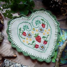 a heart shaped pillow sitting on top of a table next to some leaves and other items