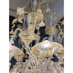 a large chandelier with many lights hanging from it's sides and glass flowers on the bottom