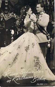 an old black and white photo of a man and woman dressed in formal clothing dancing