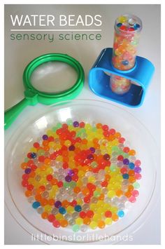 a bowl filled with gummy bears next to a pair of scissors