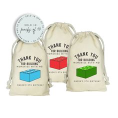 two bags with the words thank you for building blocks on them and a clock in the background