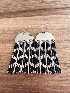 These earrings have a modern feel with their black and tan geometric design. Beading hangs from a beautiful super shiny silver colored rhodium plated half moon form with sliver plated ear wires. **Each of my earrings are delicately handwoven bead by bead. I absolutely love making these and want you to know that each piece is made with patience and care from start to finish! These earrings are made with size 11/0 Delica Japanese Miyuki seed beads. I use strong nylon thread to ensure the integrity Trendy Nickel-free Silver Beaded Earrings, Trendy Silver Nickel-free Beaded Earrings, Trendy Silver Beaded Earrings, Bohemian Black Earrings With Silver Beads, Trendy Adjustable Silver Beaded Earrings, Trendy Black Dangle Beaded Earrings, Shiny Silver, Fringe Earrings, Beaded Dangles